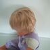 Szőke hajú retro baba lila kantáros rugdalózóban